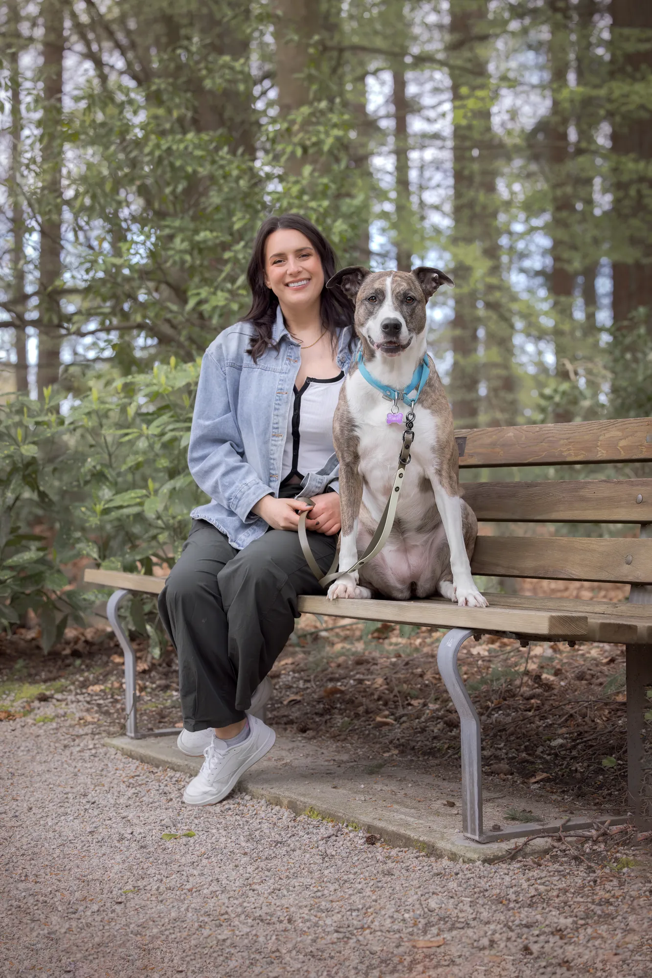 Lea Mestrovic sitting on a park bench with her brindle dog
